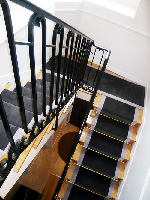 tapis noir et gris dans un escalier droit en bois