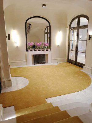 hall avec un tapis jaune et cheminée