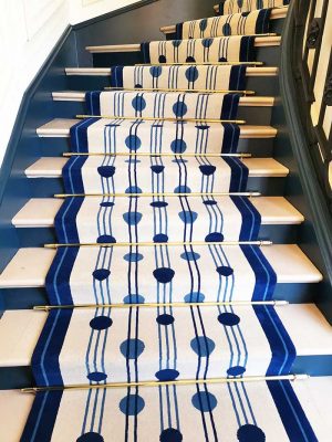 tapis à pois bleus et lignes noires posé dans un escalier en pierre