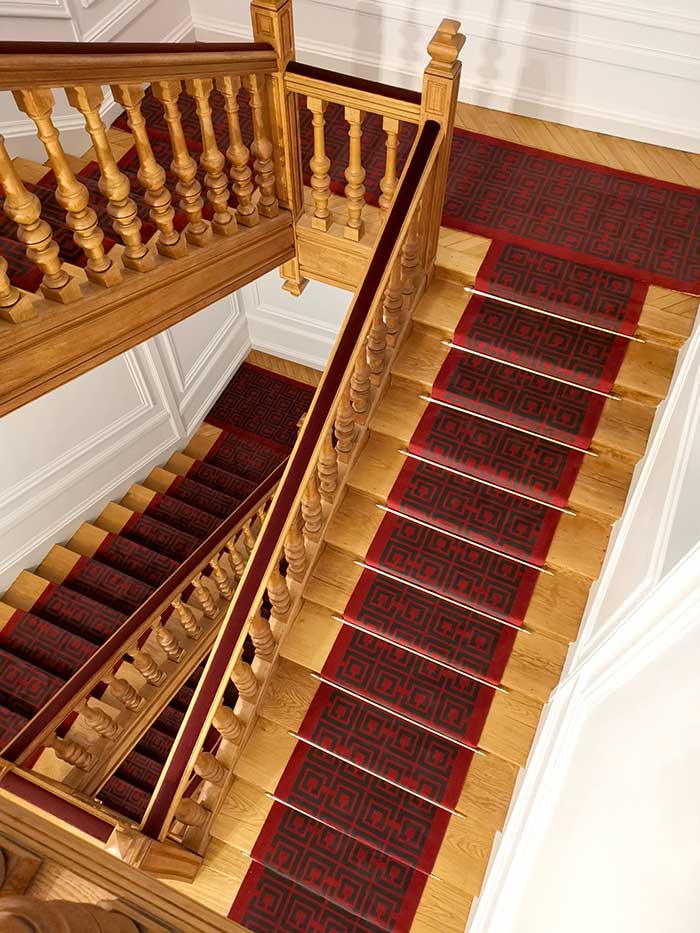 escalier en bois avec tapis rouge