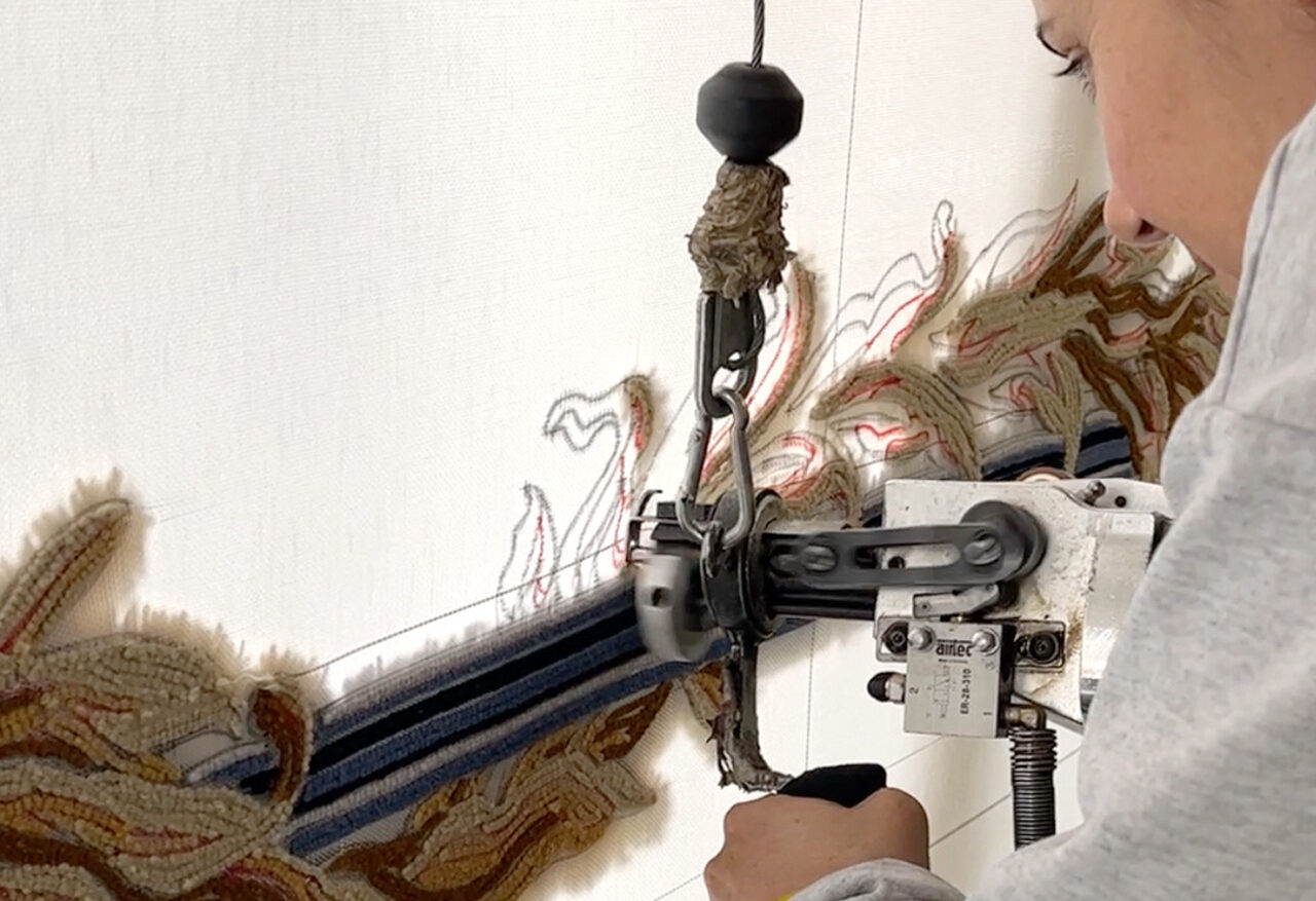 Artisan réalisant un tapis en tufting