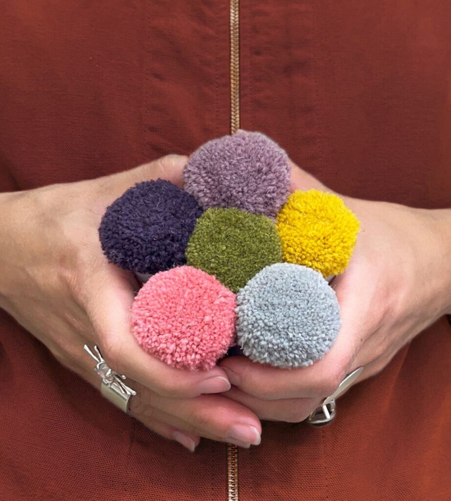 Pompons de tapis sur mesure tenus en main