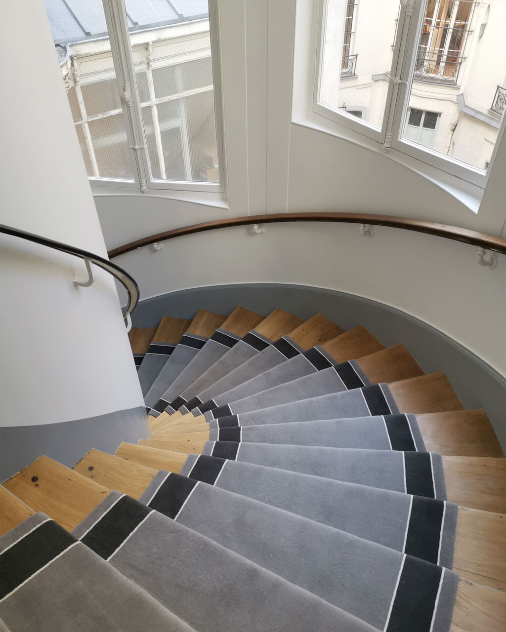 Tapis gris dans un escalier en bois clair